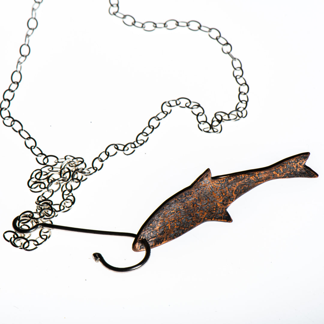 Cobble Stone Designs of Montana's Copper Fish with Sterling Silver Hook Necklace, a fun fishing-inspired silver and copper necklace made in Montana