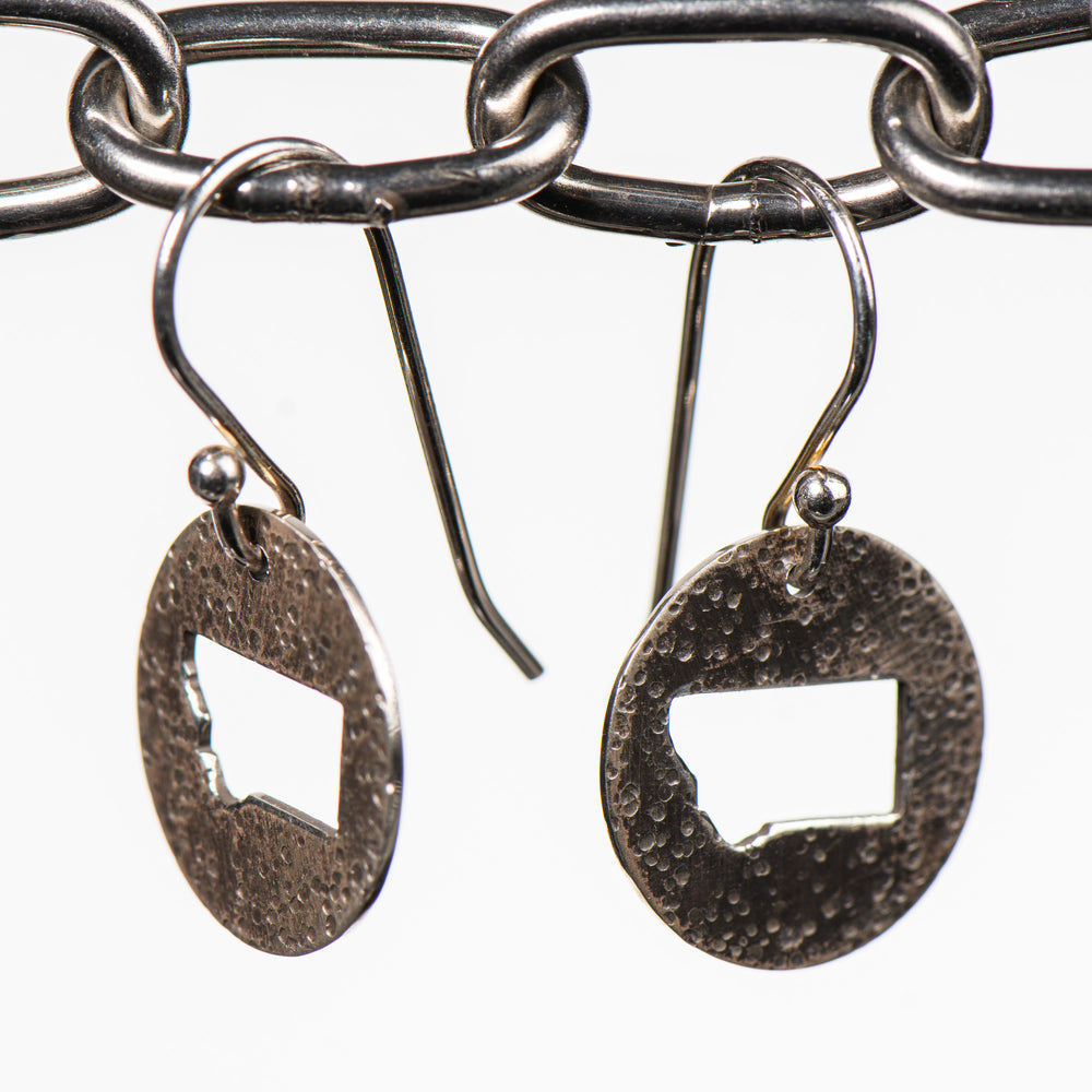 Cobblestone Design of Montana's Disc Earrings, handcrafted earrings featuring a hammered sterling silver disc with a Montana-shaped cutout