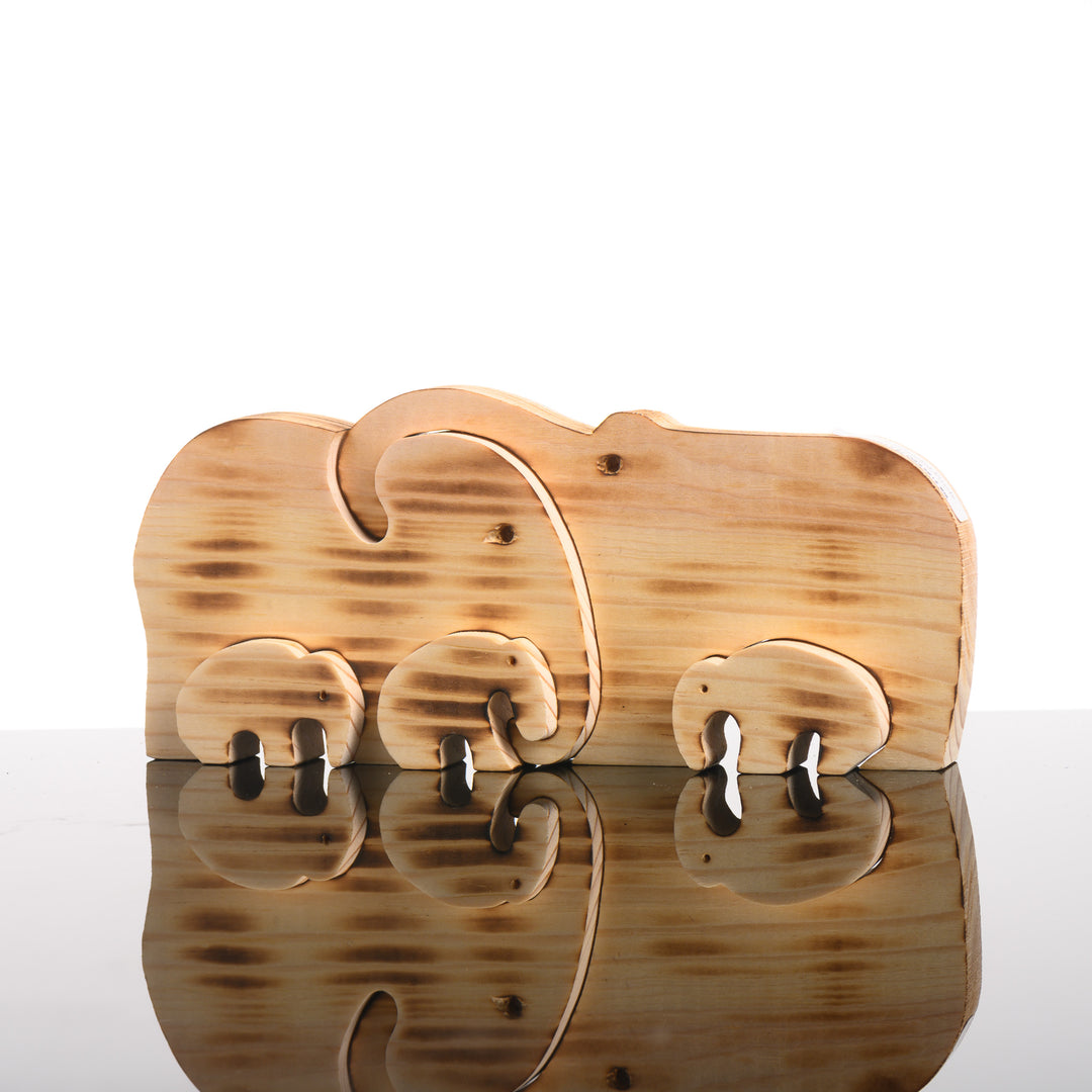 A handmade wood puzzle featuring a mama elephant, a dad and three baby elephants.