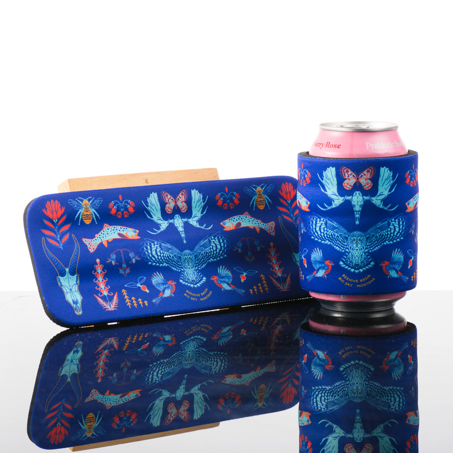 This blue slap can cooler features artwork inspired by beehive basin in Big Sky, Montana.