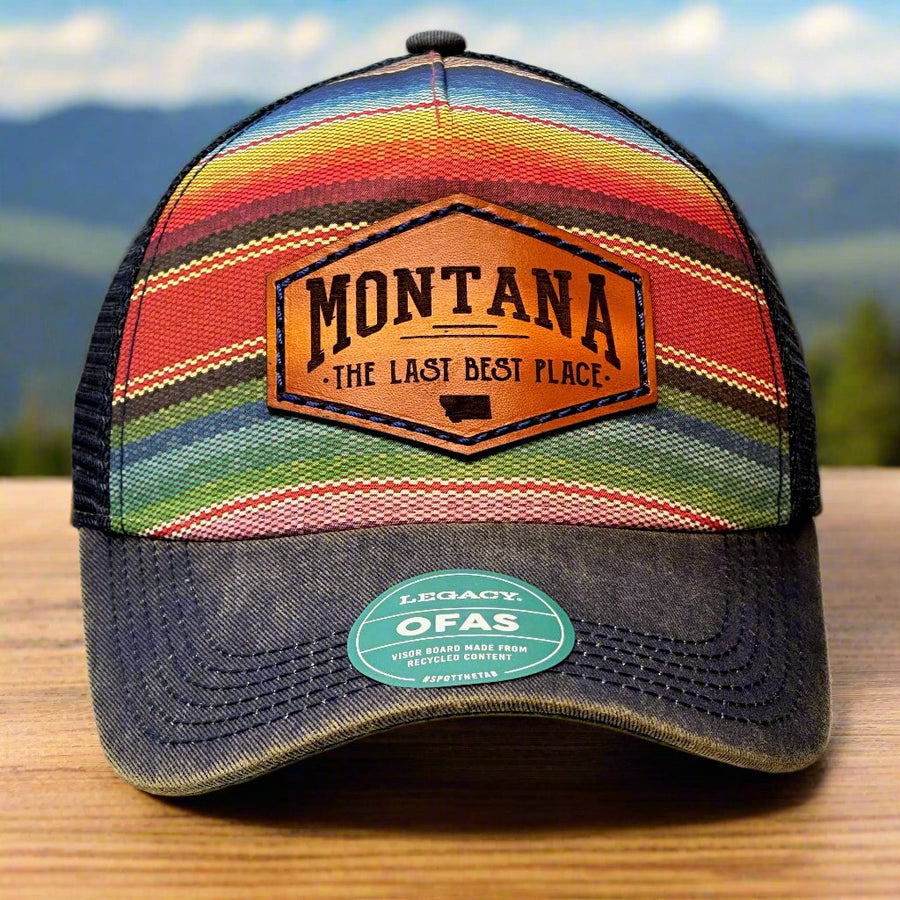 A poncho printed trucker hat with a thick leather patch that says Montana, The Last Best Place.