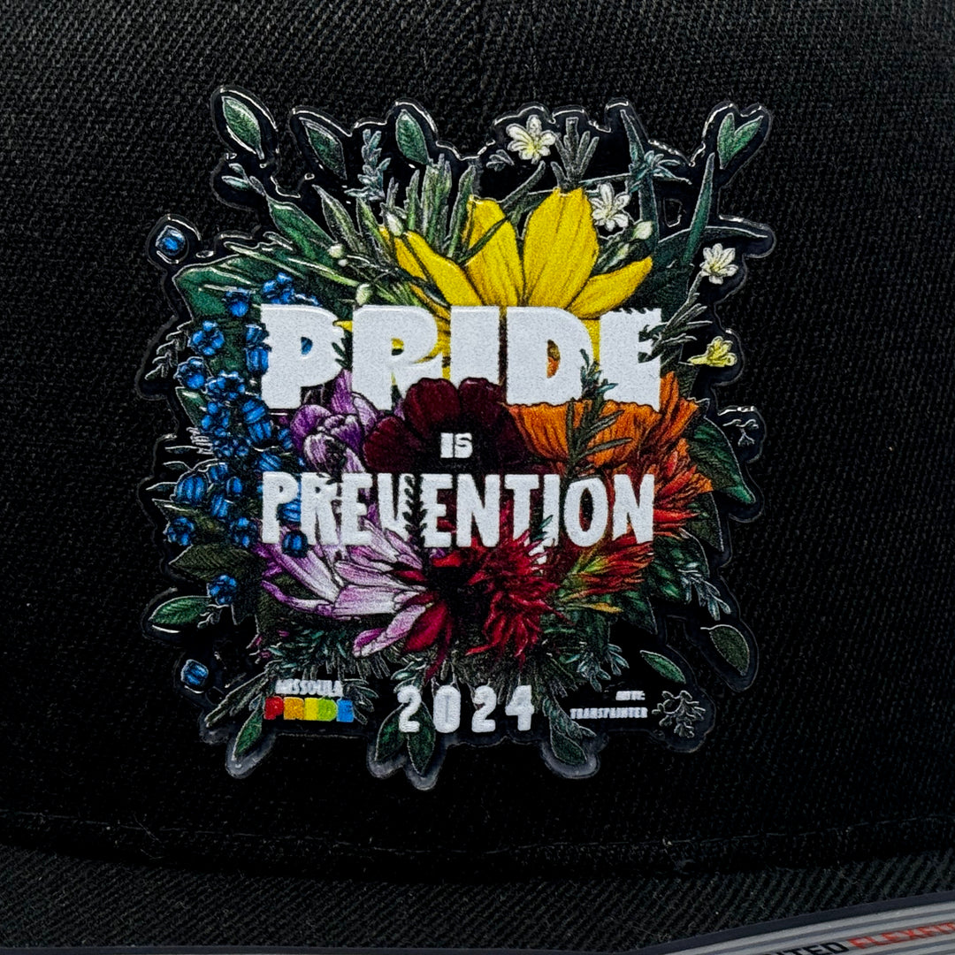 Black flat bill hat featuring the 2024 Missoula PRIDE design Pride is Prevention, closeup patch detail