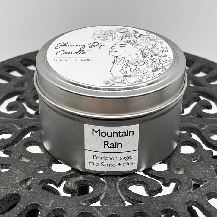 4 oz. tin of Skinny Dip Candle's Mountain Rain Lotion Candle, front