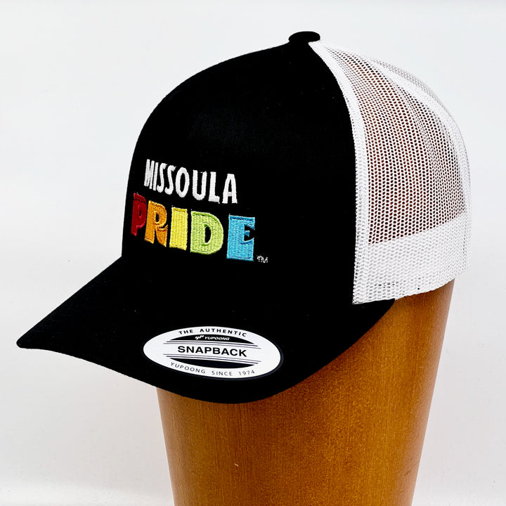 Black and White Retro Trucker Hat featuring the Missoula PRIDE logo, 3/4 view