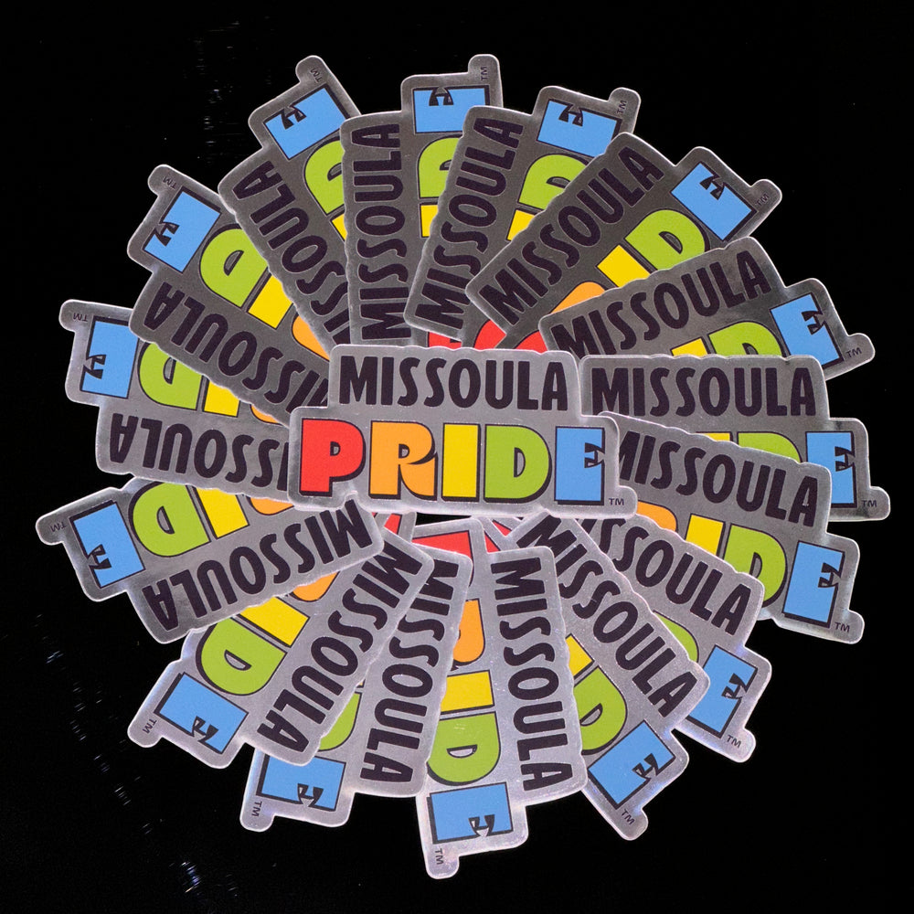 Circled group of Missoula PRIDE stickers with "PRIDE" in rainbow tones, on a chrome background