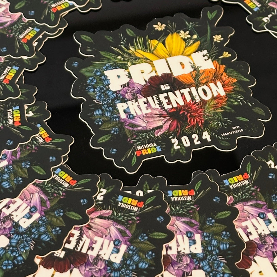 Circled group of black stickers featuring the featuring the 2024 Missoula PRIDE 'Pride is Prevention' design, closeup