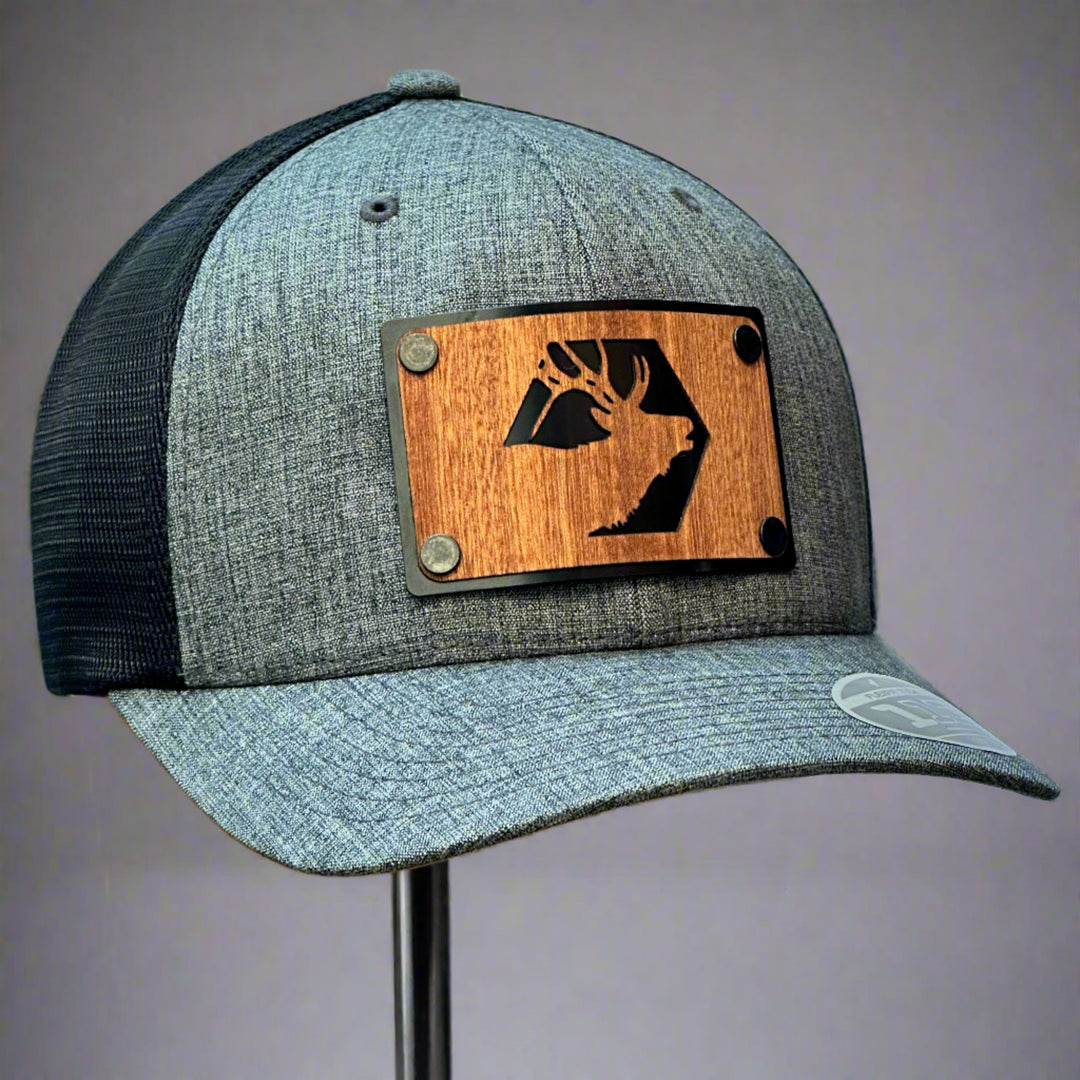 A grey and black trucker hat with a mahogany elk patch