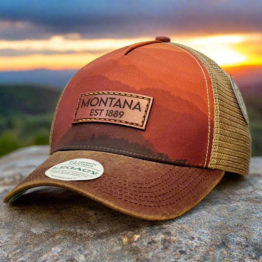 A thick stitch leather patch that says Montana on a mountain printed trucker hat