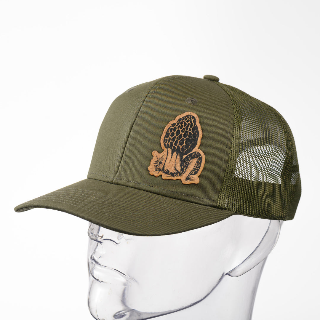 A green trucker hat with a morel mushroom wood patch