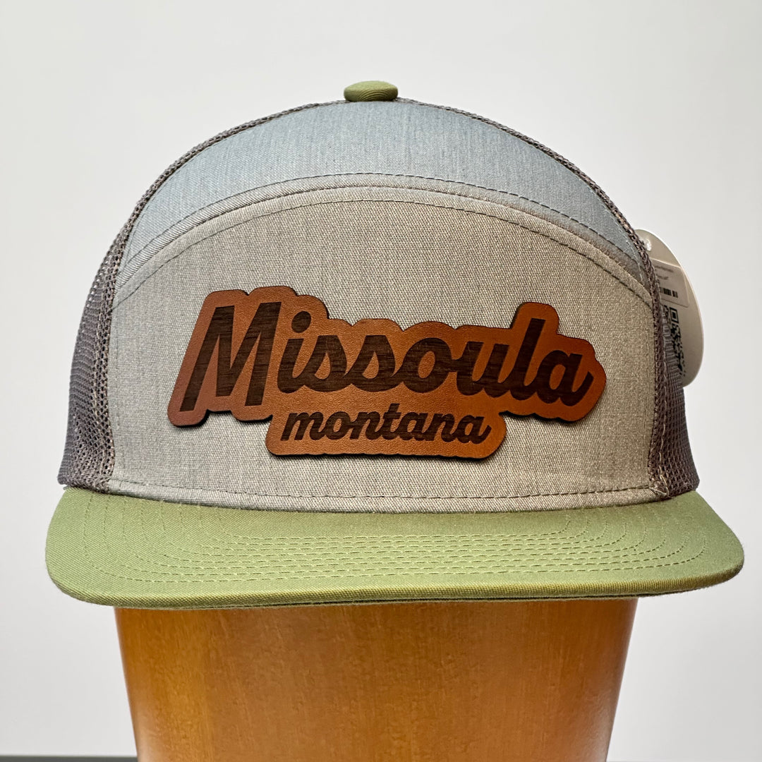 A hand dyed leather patch, made in Montana, spelling out the words Missoula Montana on a premium flatbill trucker hat