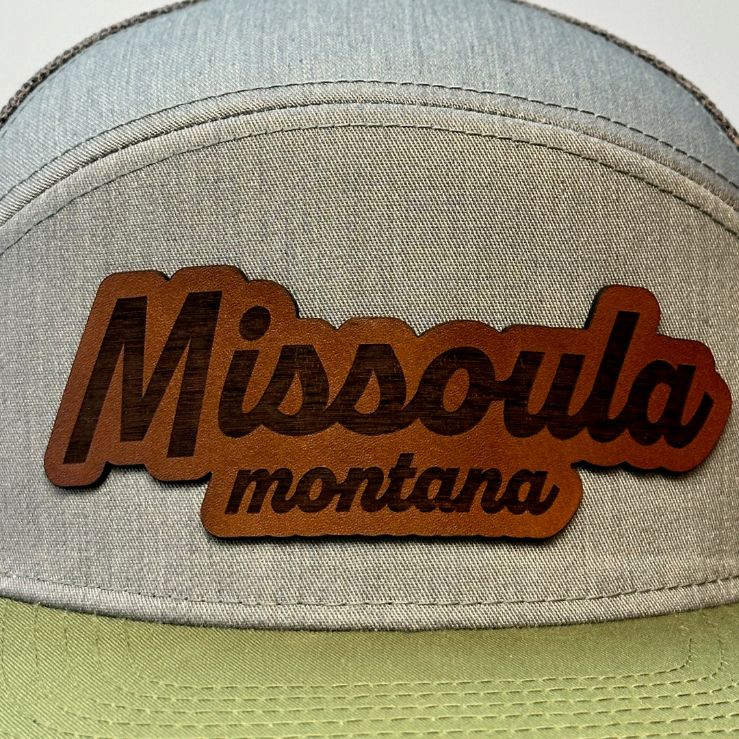 A hand dyed leather patch, made in Montana, spelling out the words Missoula Montana on a premium flatbill trucker hat