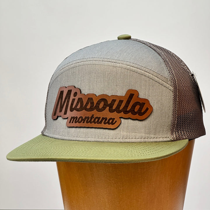 A hand dyed leather patch, made in Montana, spelling out the words Missoula Montana on a premium flatbill trucker hat