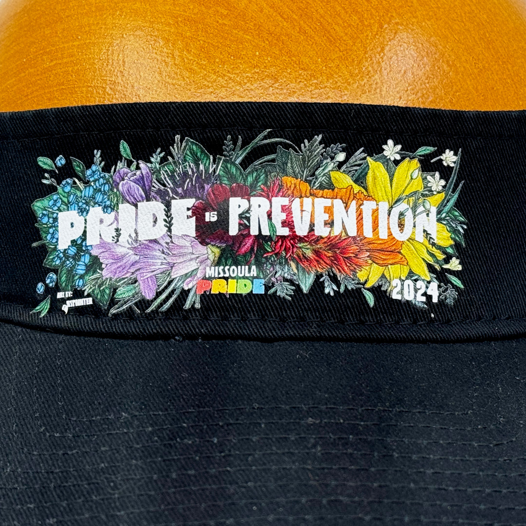 Black visor featuring the 2024 Missoula Pride design Pride is Prevention design; a portion of sales are donated to the Missoula Pride fundraiser.