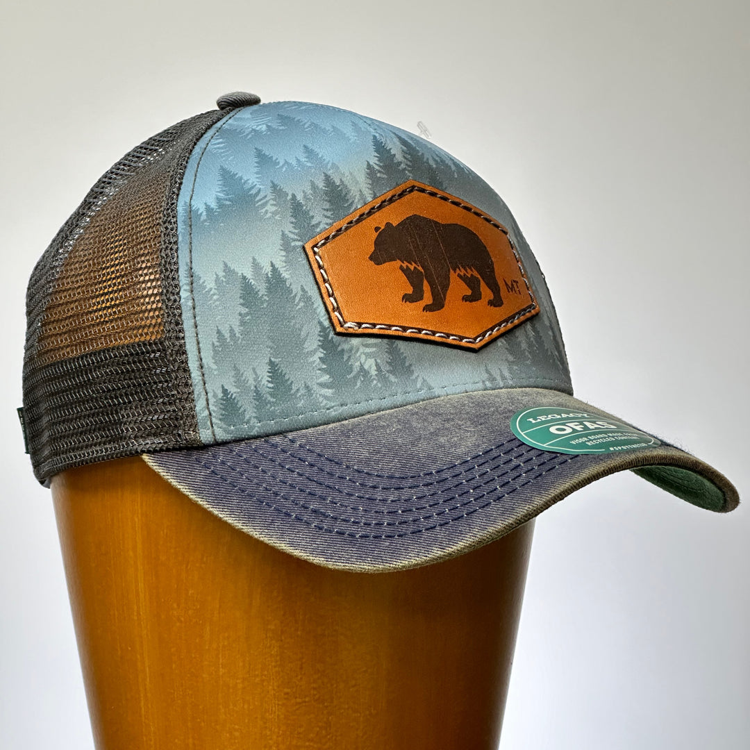 This is the side profile of a hand dyed leather patch, made in Montana, in the shape of a Bear with the letters MT underneath, legacy trucker hat