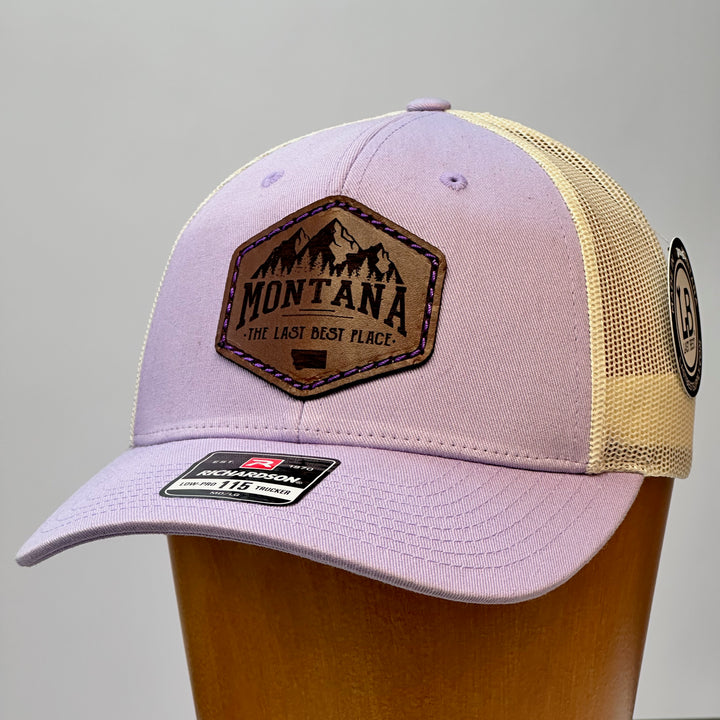 A lavender purple Richardson trucker hat with a leather patch that reads Montana the Last best Place and features purple thread.