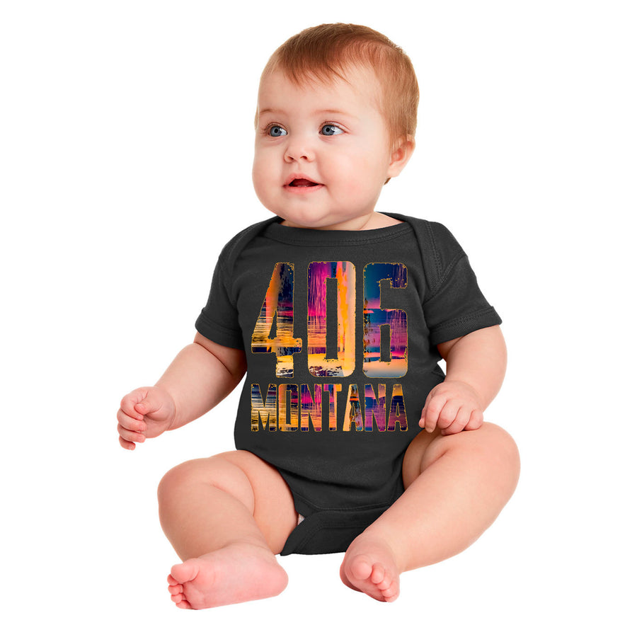 A baby wearing a black onesie with a vivid print of the 406 Montana design