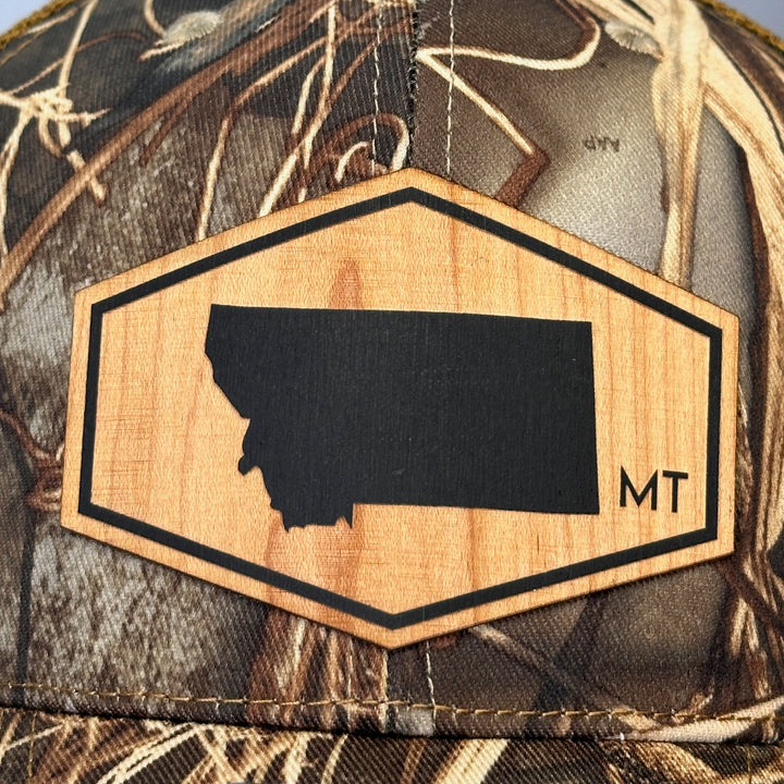 A close up of a large hexagon wood patch with the state of Montana on it