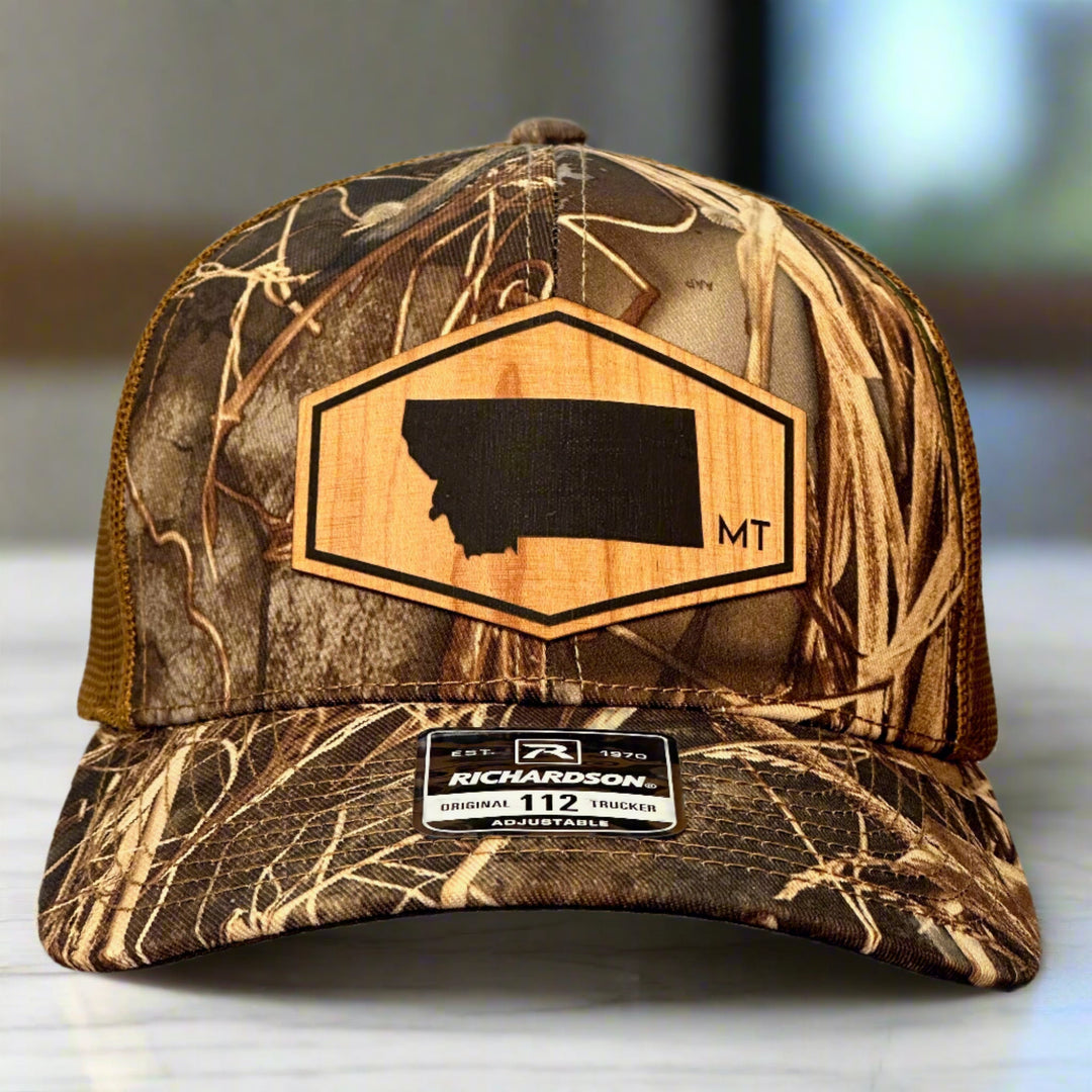 A mossy oak camo richardson trucker hat with a wood patch