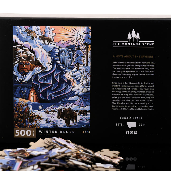 This hand drawn 500 piece puzzle is titled Winter Blues and features a snowy landscape with a cozy cabin and is made by The Montana Scene in Kalispell, Montana; image depicts box back with puzzle pieces.