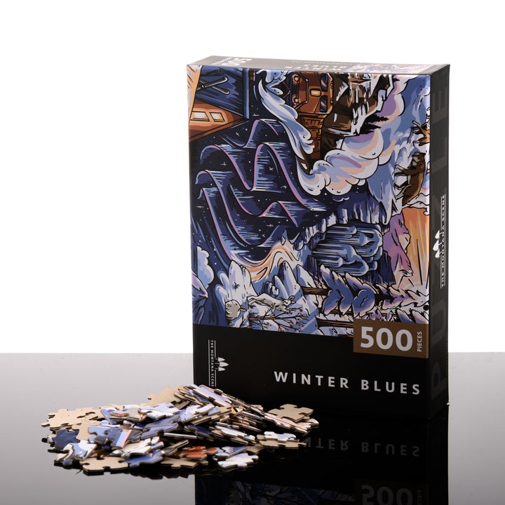 This hand drawn 500 piece puzzle is titled Winter Blues and features a snowy landscape with a cozy cabin and is made by The Montana Scene in Kalispell, Montana; image depicts box front with puzzle pieces.