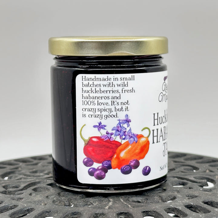 6 oz. jar of Key to the Mountain's Montana made Huckleberry Habanero Jam, description reading handmade in small batches with wild huckleberries, fresh habaneros and 100% love.