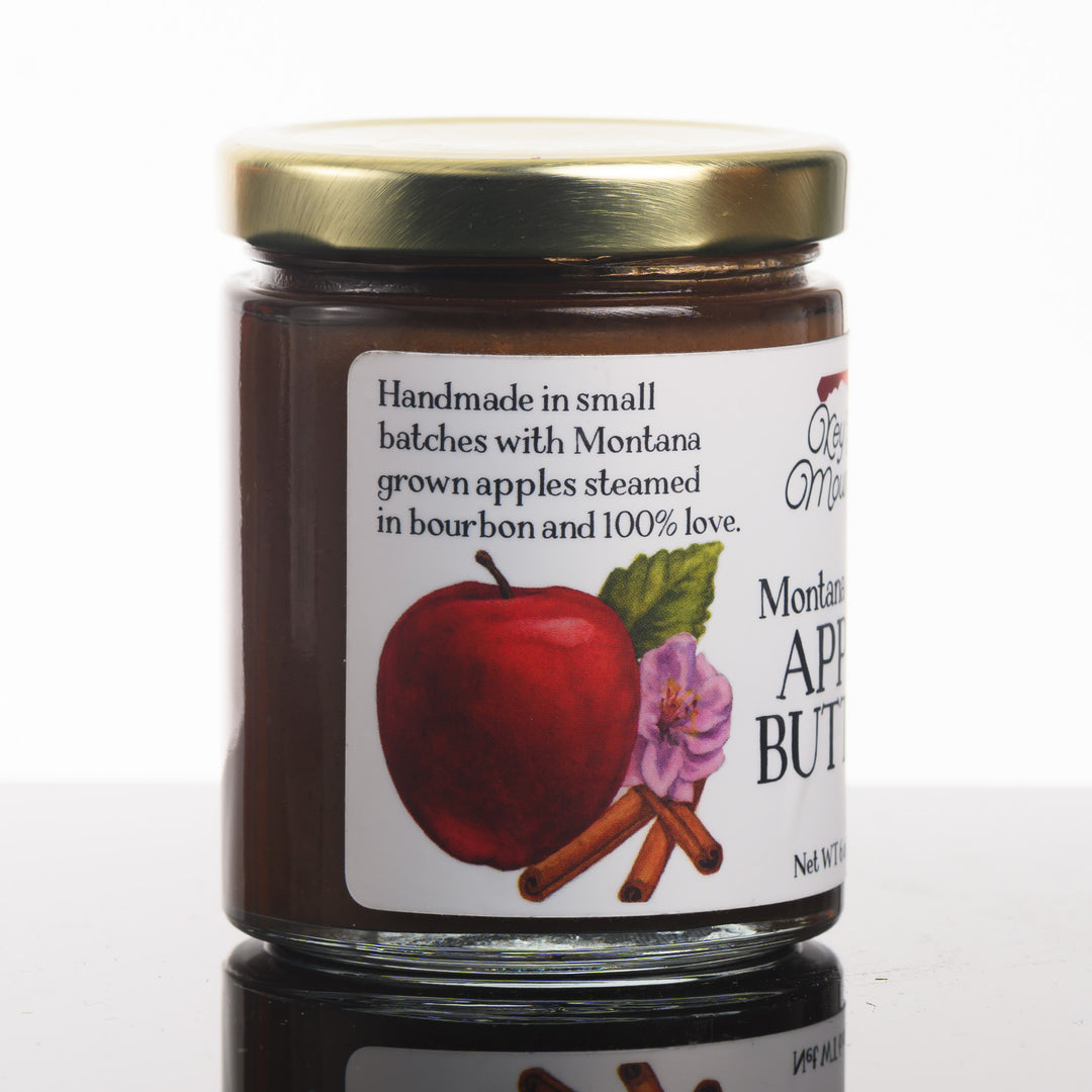 A picture of the side of a 6 ounce jar of Montana grown apple butter that reads: handmade in small batches with Montana grown apples steamed in bourbon and 100% love.