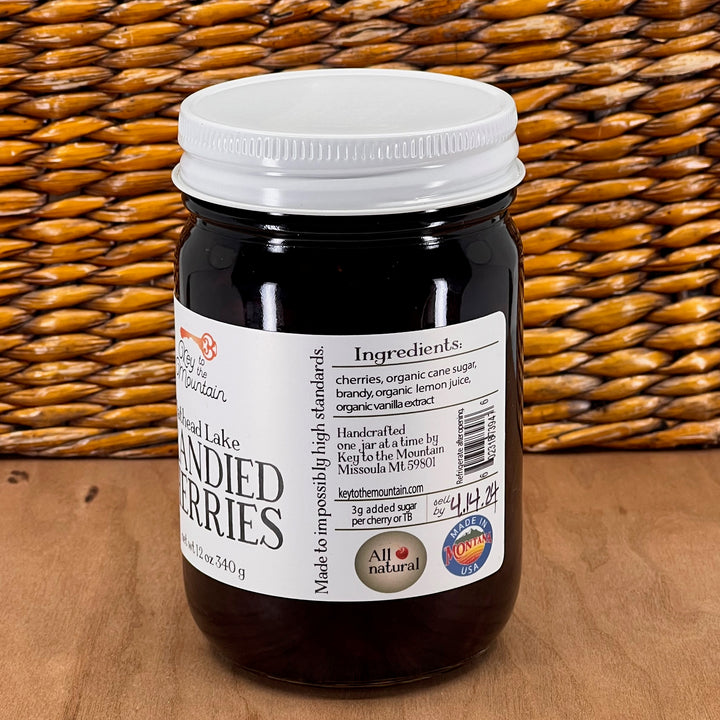 A 12 ounce jar of Key to the Mountain's Montana made Flathead Lake brandied cherries listing the ingredients: cherries, organic cane sugar, brandy, organic lemon juice, organic vanilla extract.